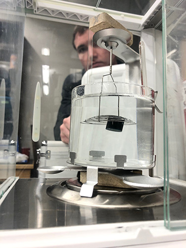 CAMP employees measuring the specific gravity of a wax fuel 2