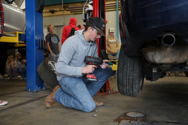 A student changes a tire.