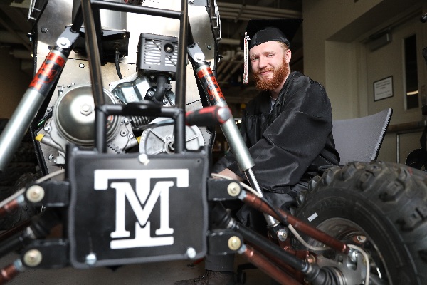 !Francis Rogers with the Baja buggy, in his cap and gown