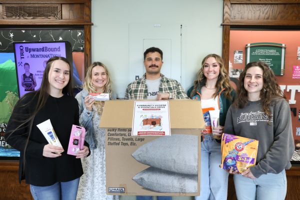 !Nursing students pose with hygiene items at a drop box