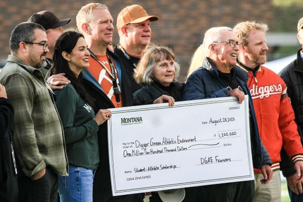 A group stands together at the check presentation