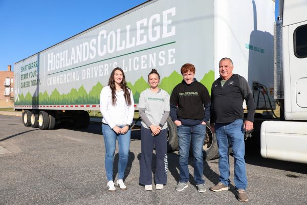 !Students and Highlands College representatives pose for a photo in front of a commercial truck