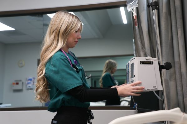 a nursing student works with a modle